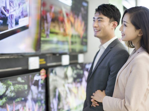 Young Chinese couple buying television in electronics store